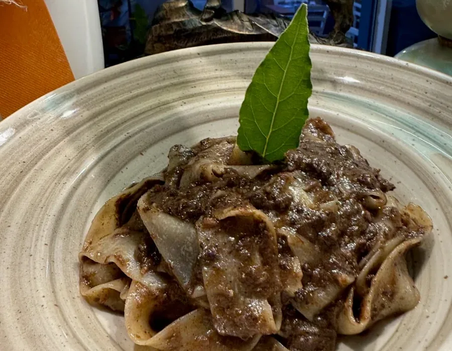 Piatto di cinghiale in umido con pappardelle e foglia di alloro
